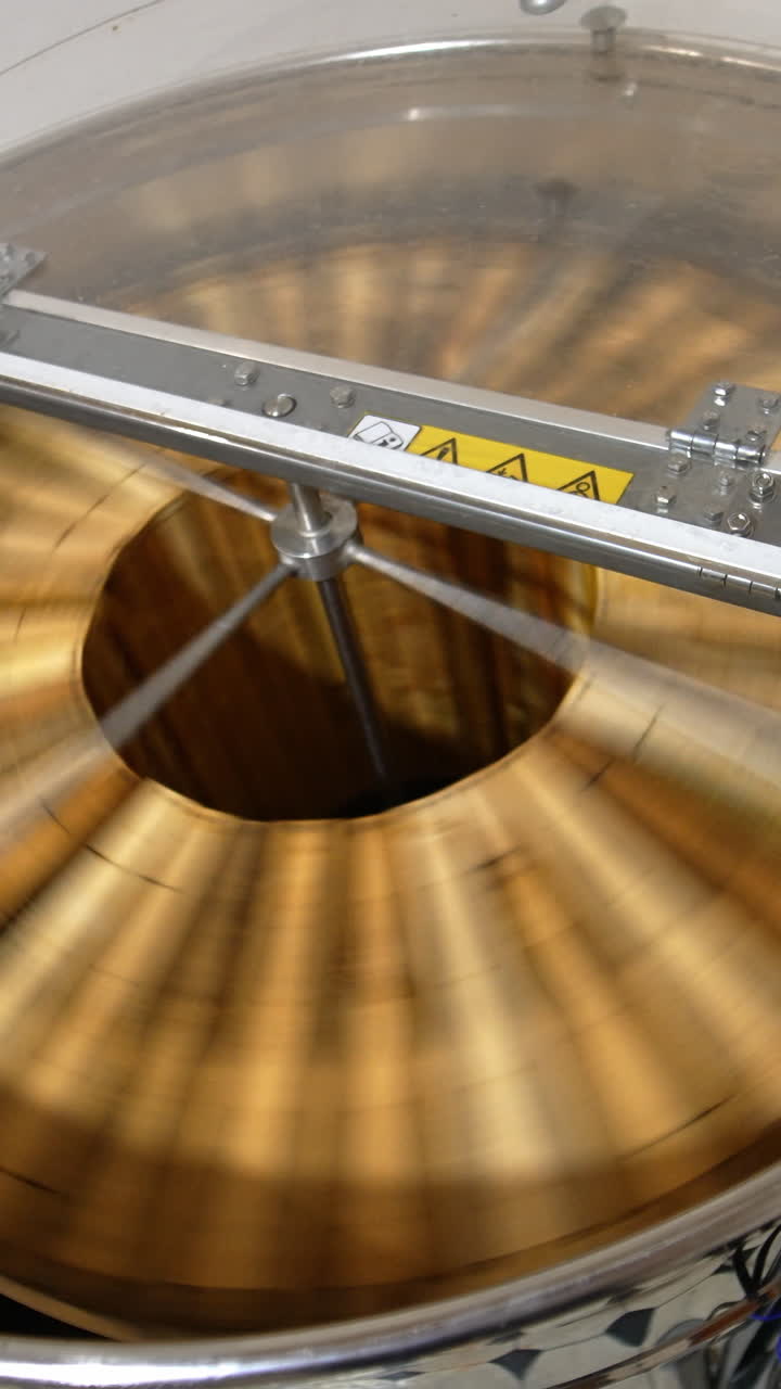 Honey extraction in the electric machine working in the apiary. Apparatus rotating frames to gather honey harvest. Top view. Vertical video