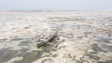 drone shot orbiting destroyed and broken wooden boat on africa coast