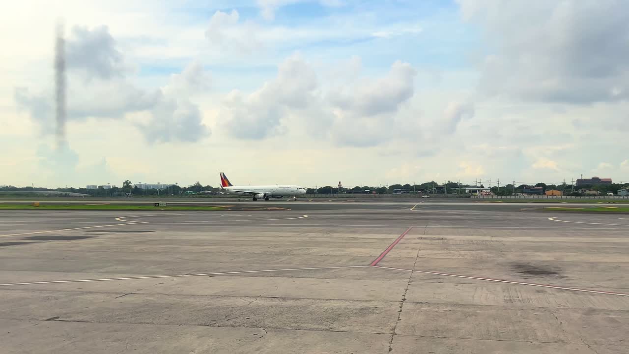 Wide shot of an airplane taxiing on an airport runway with a cloudy sky backdrop, perfect for aviation, travel, and transportation-themed projects