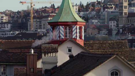 pequeña torre roja entre chimeneas humeantes, pájaros volando
