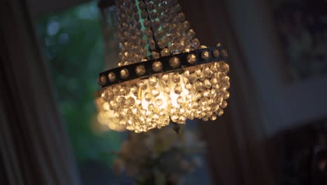 una lámpara de cristal colgando del techo con una luz cálida brillando sobre ella