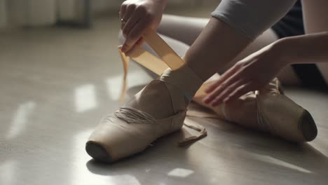 ballerina tying pointe shoes