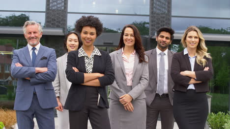 portrait of smiling multi-cultural business team outside modern office building