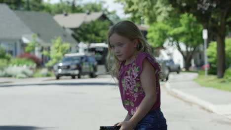 surprised little girl takes off headphones while crossing street
