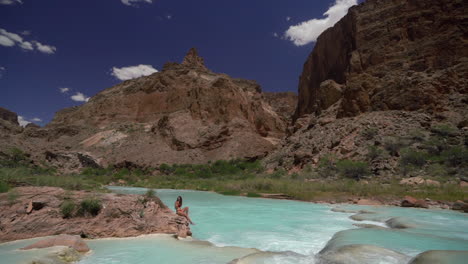 mujer en traje de baño disfrutando en el agua del río turquesa, joya escondida del parque nacional del gran cañón, sendero de sal hopi, cámara lenta