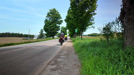 2 cyclotourists riding on road in quebec canada