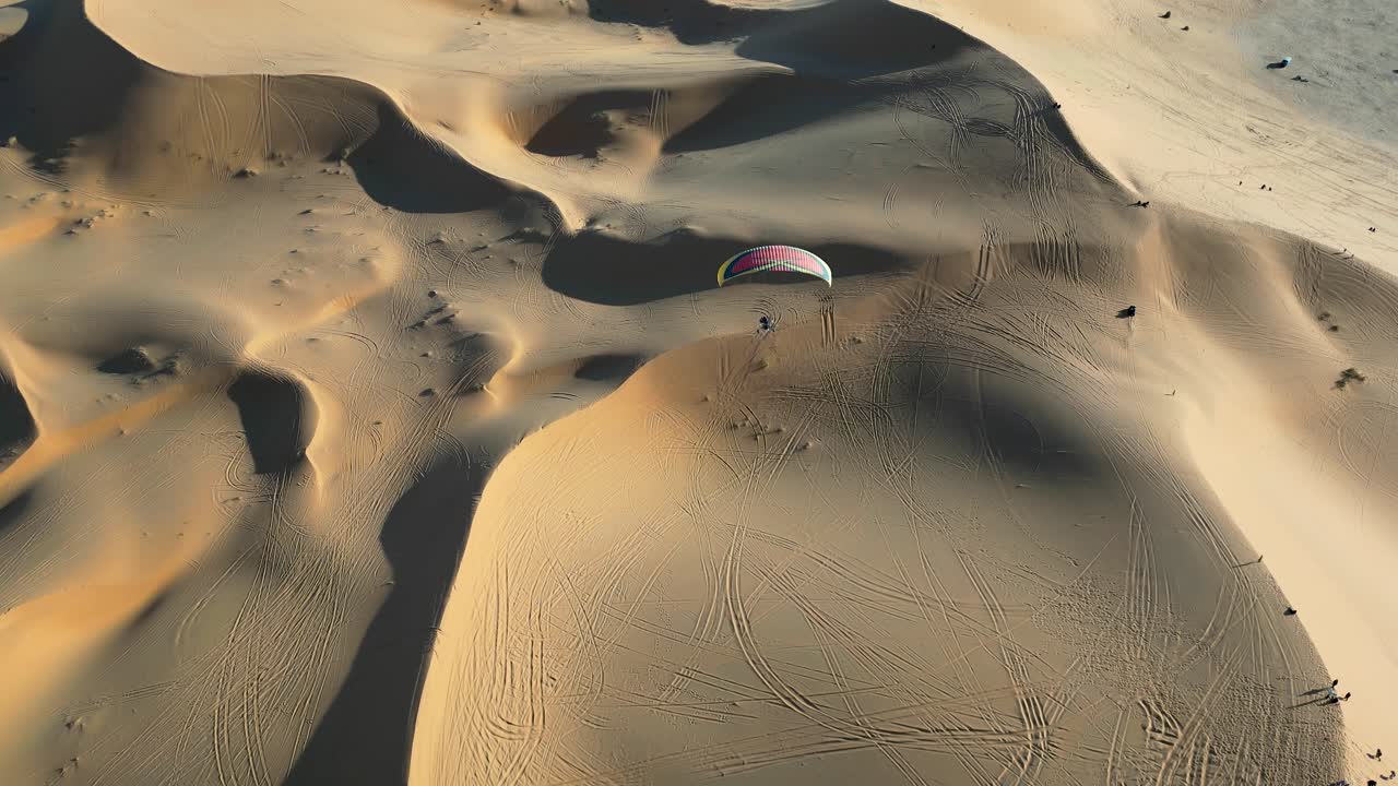 Fly above the endless sand dunes of the Algerian Sahara with a paramotor. Enjoy breathtaking aerial views of the vast desert landscape, capturing the serene beauty of the golden sands.
