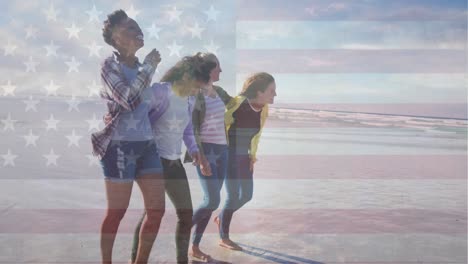 Animation-of-flag-of-america-waving-over-diverse-female-friends-talking-and-laughing-on-beach