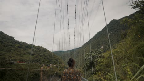 Man-walking-over-a-bridge-during-Waterfalls-tour-in-Baños-Ecuador