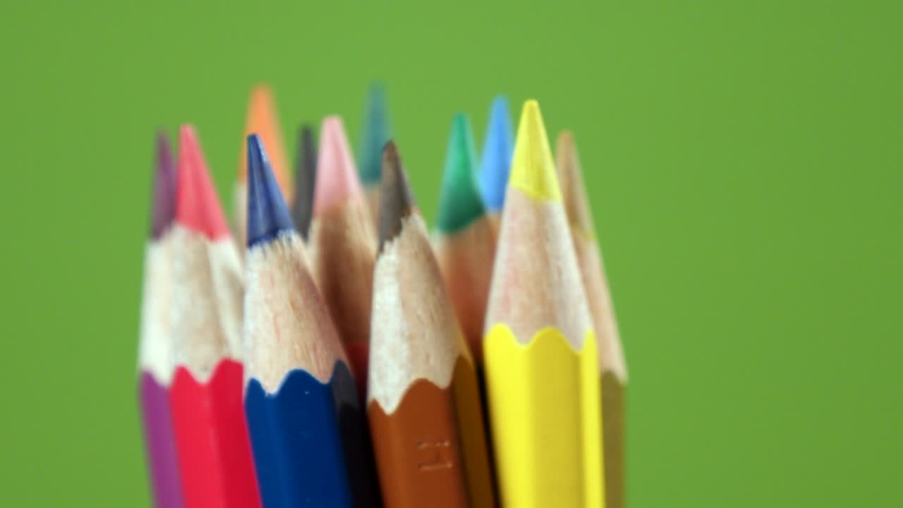 lápices de color girando sobre un fondo verde