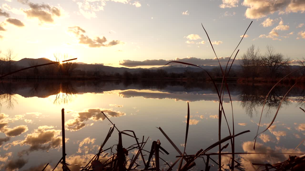 Reflection of sunset and clouds over lake surface