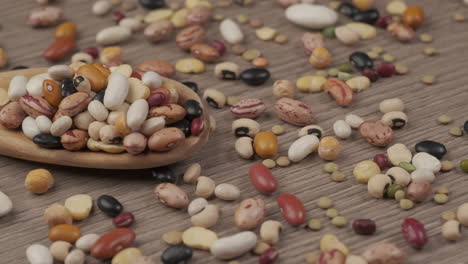 dry legumes, mixed beans, chickpeas, lentils, soup on wooden spoon, mediterranean healthy diet nutrition