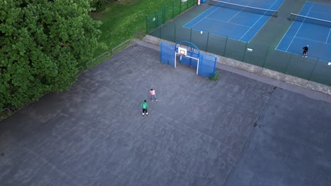 Jóvenes-Activos-Jugando-Baloncesto-1v1-En-Una-Cancha-De-Asfalto-Al-Aire-Libre-En-El-Parque-De-La-Ciudad