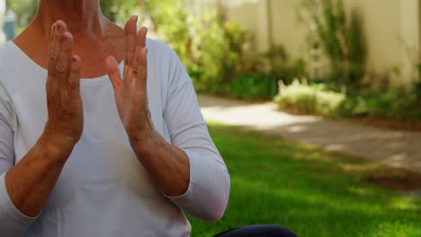 mujer mayor realizando yoga en el jardín 4k
