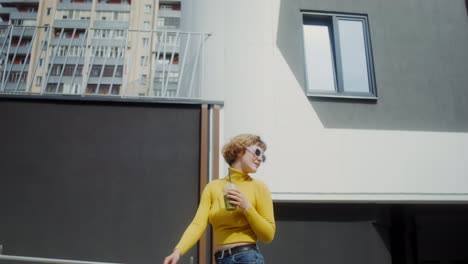 woman enjoying a smoothie in front of a modern building