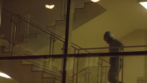 person walking down stairs in a building at night