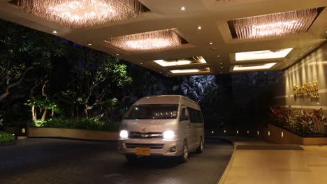 vehicles passing under illuminated archway at night