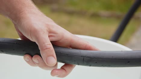 mano que muestra un agujero de pinchazo en un neumático de bicicleta