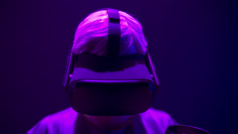 guy helmet enjoying 3d movie in neon light closeup. focused man watching headset