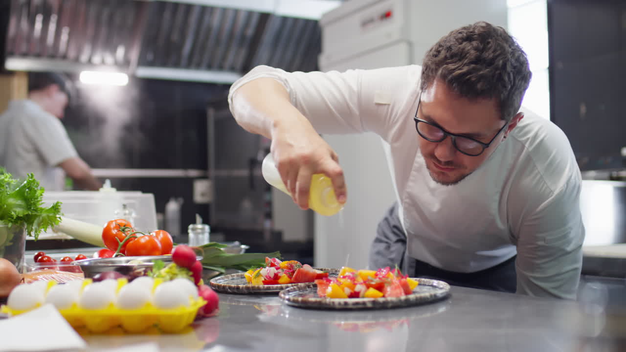 Chef Dressing Salad with Olive Oil in Restaurant Kitchen