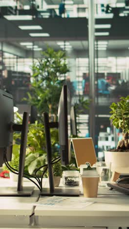 vertical video employee arriving in office, looking over revenue figures on documents