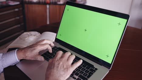 old italian author and university professor in retirement typing on computer keyboard with green screen chroma key, senior writer planning book story and writing down for publication. old italian man