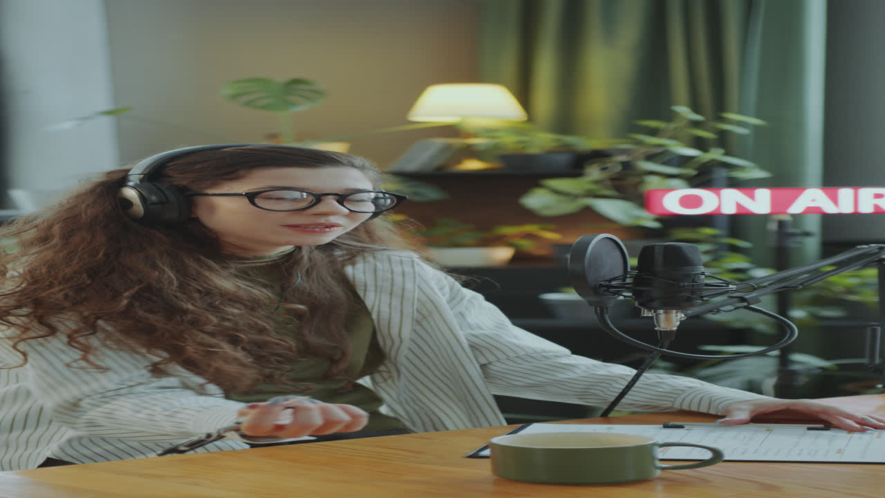 joven presentadora de podcasts escribiendo el plan de contenido y grabando el episodio en el estudio