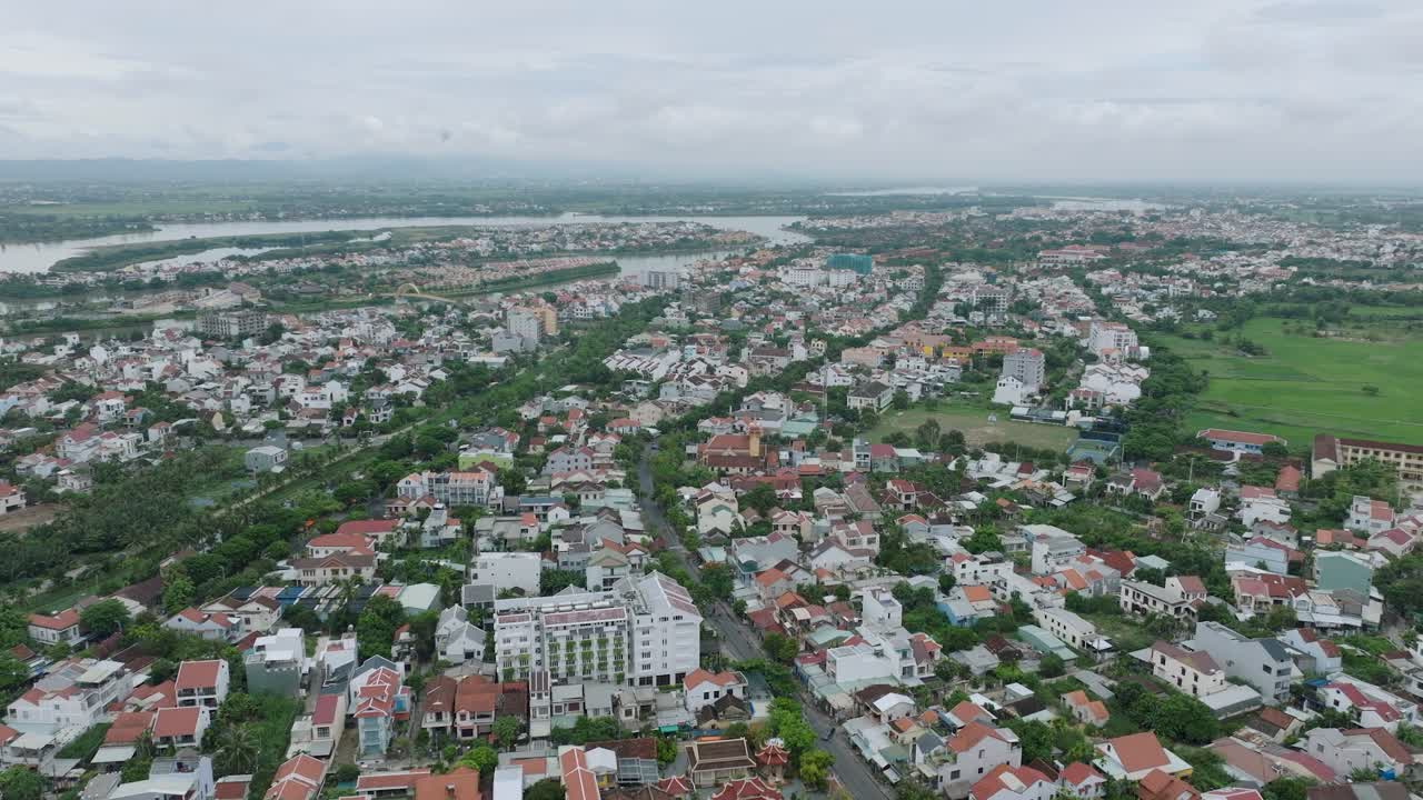 Hoi an city with houses, roads, greenery, and river in vietnam, aerial view