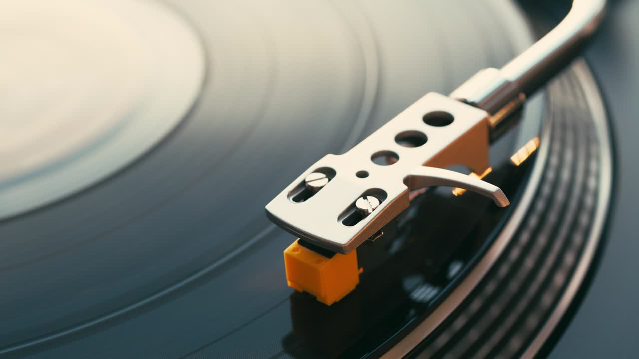 Vinyl record on DJ turntable record player close up. Moment rotating vinyl black plate. Macro. Side view. Women’s hand puts and lowers stylus smoothly with needle. Popular Disco Trends 70s, 80s, 90s