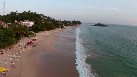 toma real de una gran ola salpicando suavemente en la playa de arena en un día soleado, sri lanka