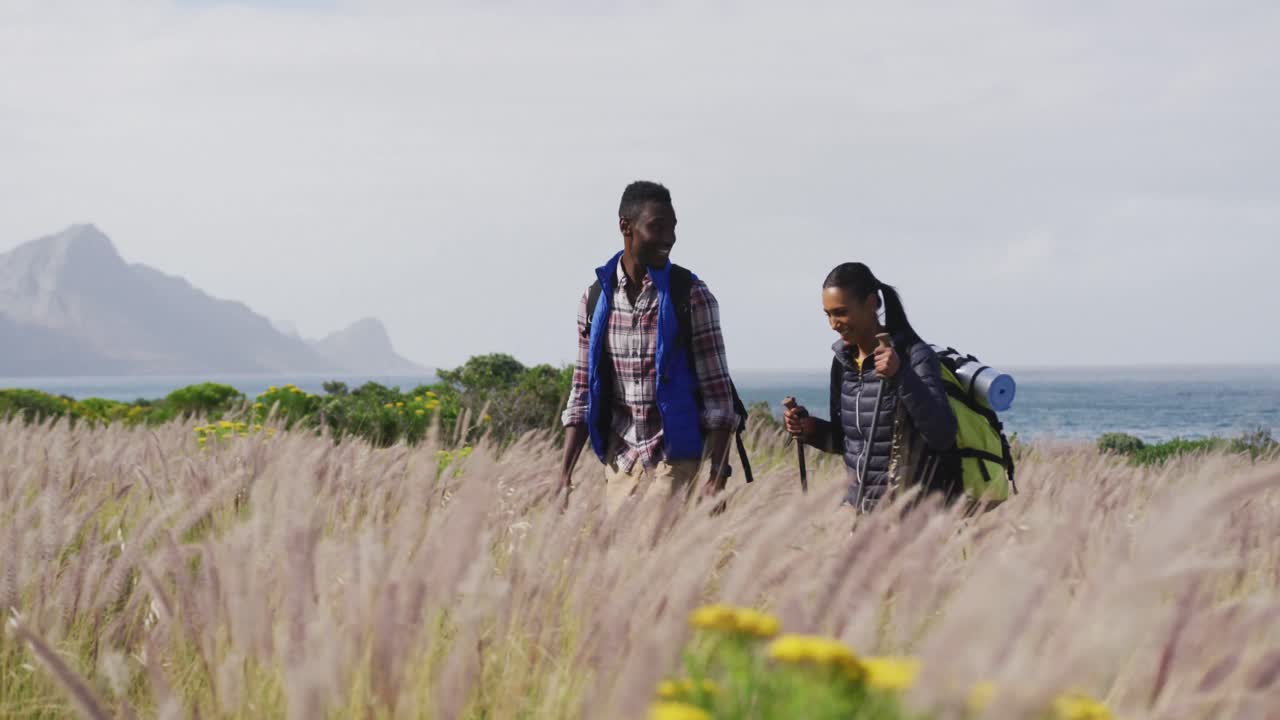 афроамериканская пара гуляет во время похода в горах