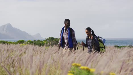 African-american-couple-walking-while-trekking-in-the-mountains