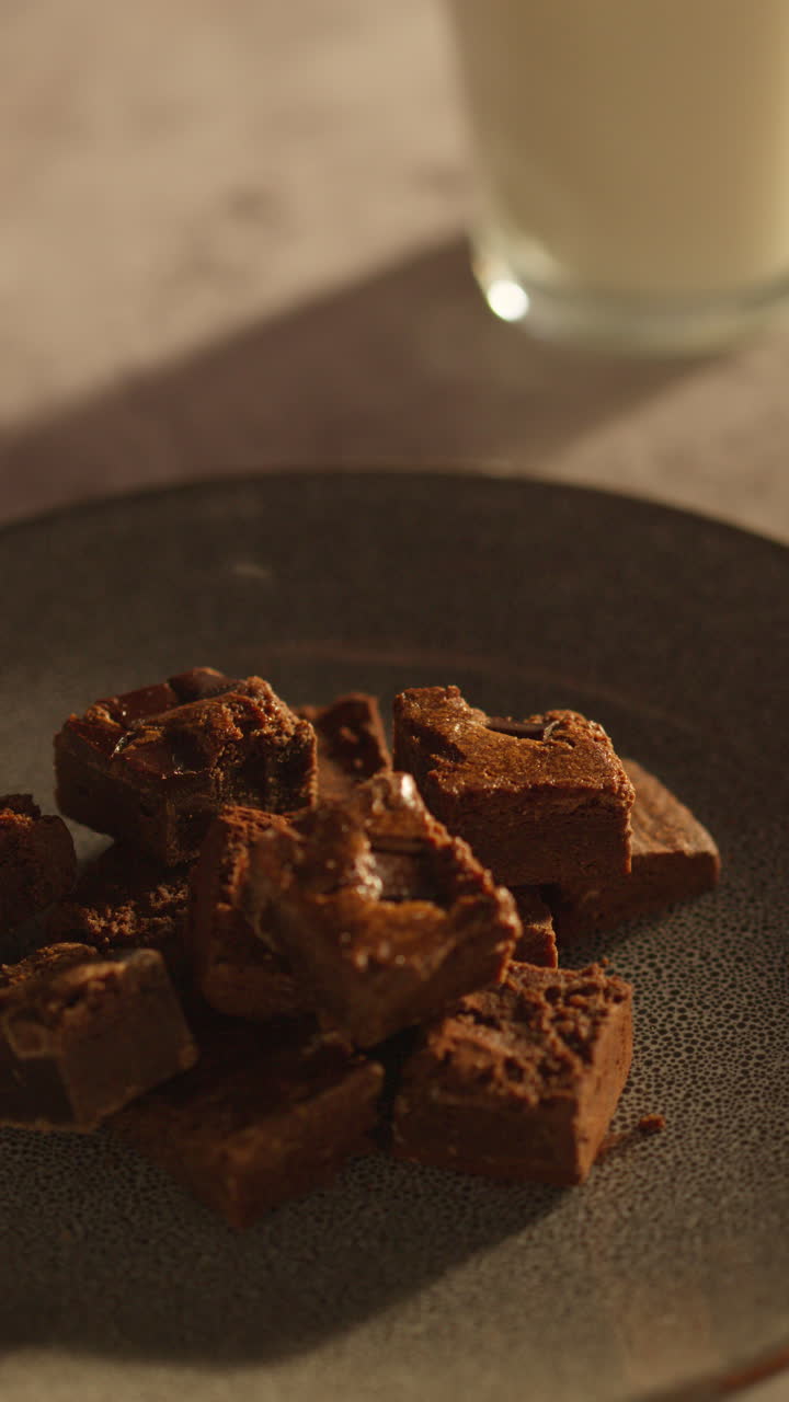 사람이 접시에서 초콜릿 브라우니를 집어 들고 먹는 수직 비디오