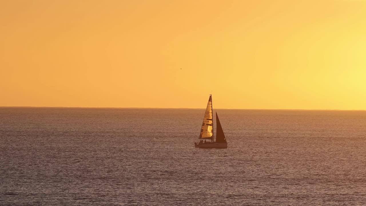 해질녘 바다에서 돛을 올리는 보트