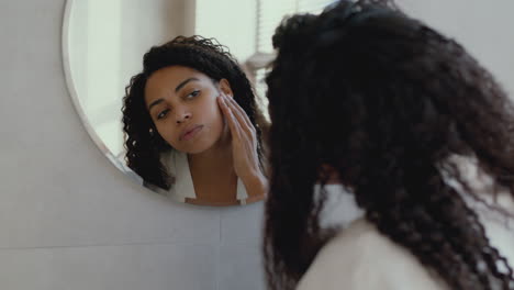woman checking her face in the mirror