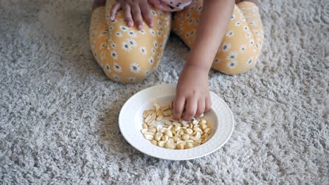 child eating cashews on the carpet