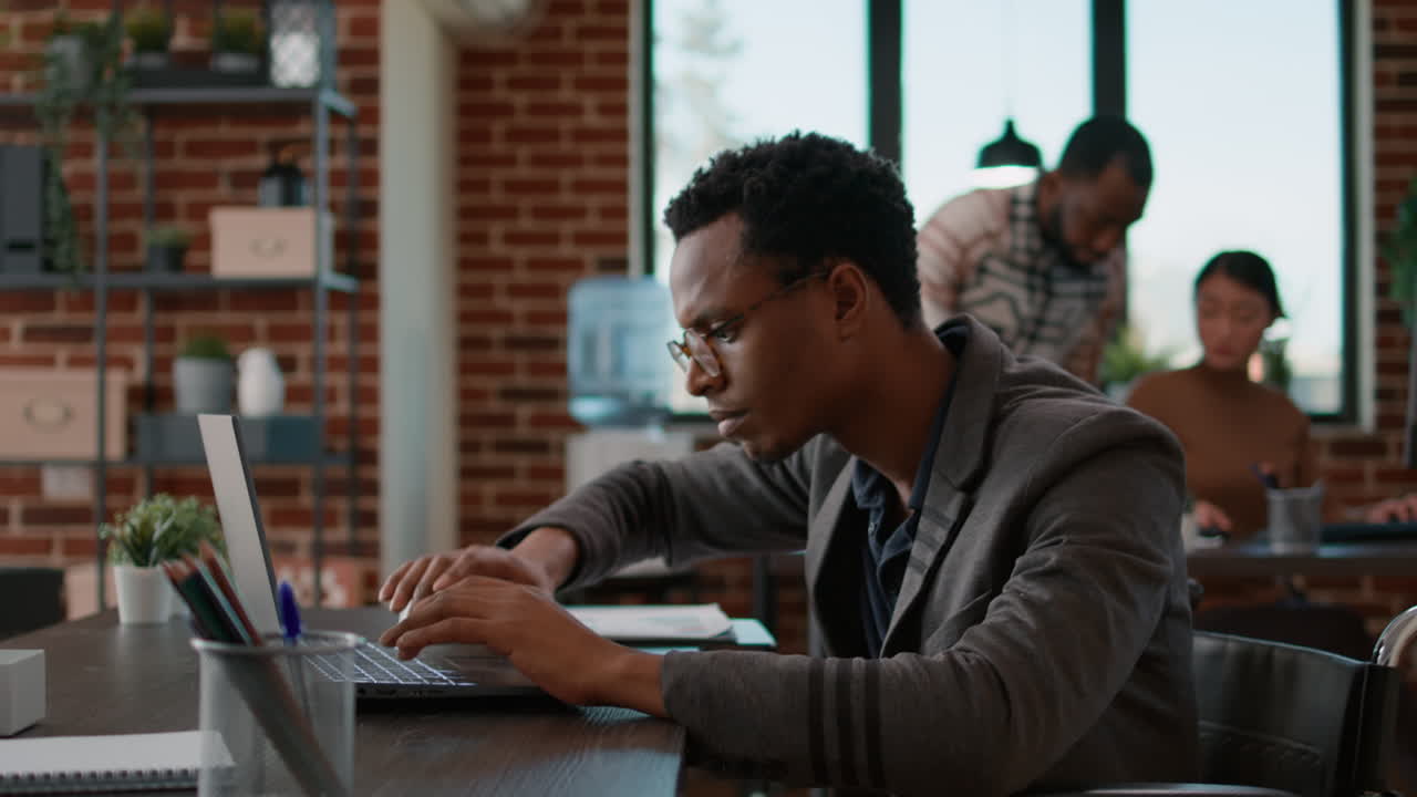 Young man analyzing business charts on laptop and files