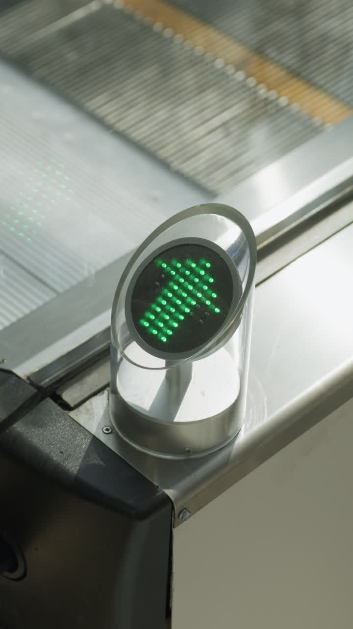vista de primer plano capturando una escalera mecánica en un centro comercial con personas que bajan. el enfoque está en los detalles mecánicos y los reflejos de las personas en la superficie metálica