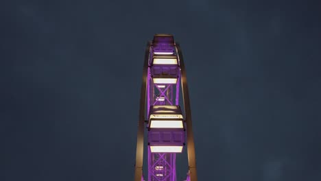 static purple ferris wheel shot in night time, low angle, up shot