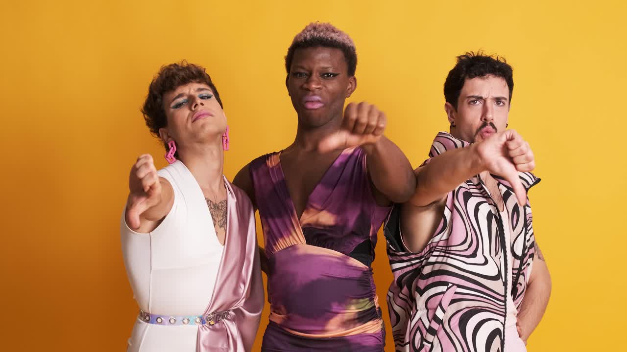 Multiethnic transgender men gesturing disapproval with their thumbs down