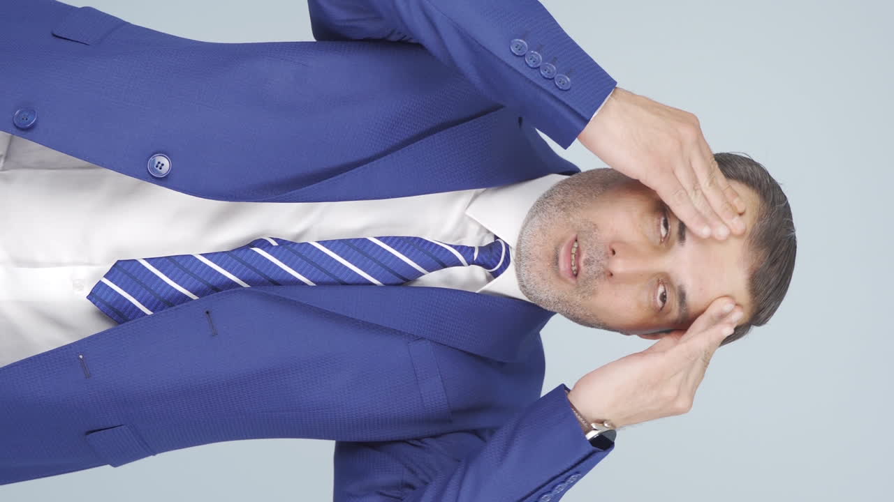 두통을  ⁇ 는 사업가의 수직 비디오.