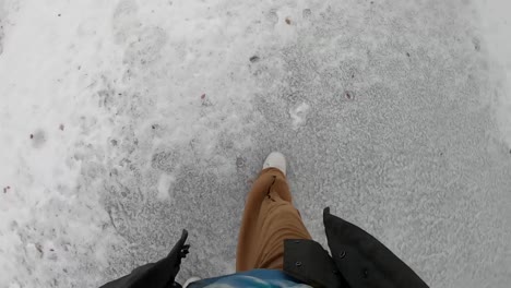 man walking on ice frozen on the street during the winter in canada