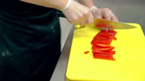 cu cook very quickly cuts a fresh bulgarian red pepper with a knife