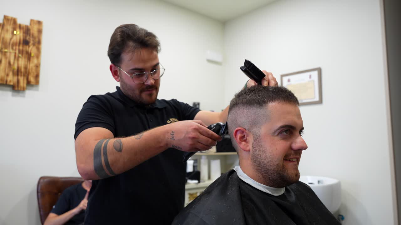 Travl barbershopscene, der viser multitasking mellem klipning og blegning.