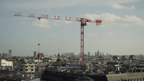 construction industry crane with load moving over city of paris during construction and repair 4k 30fps