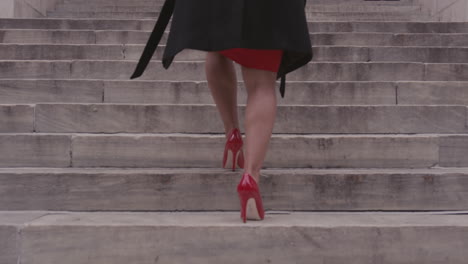 a woman climbs concrete steps in a city