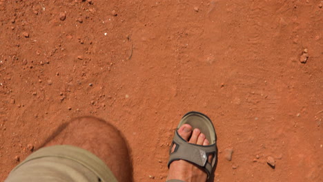 legs in trekking sandals walking on a sandy path in desert