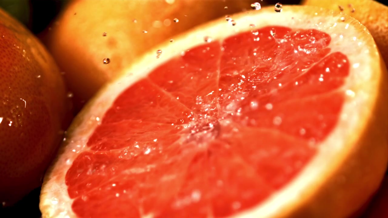 Mezza pompelmo fresco con acqua che schizza al rallentatore