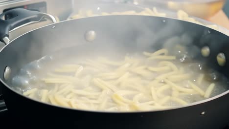 close up of pasta boiling in a pot on a stove