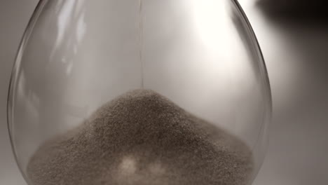 hourglass sand falling in slow motion macro